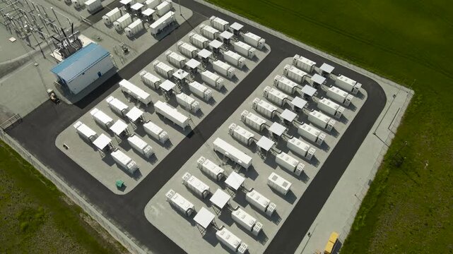 Drone perspective of a large scale BESS with rows of containerized lithium ion batteries, a crucial technology for storing renewable energy and stabilizing the power grid infrastructure