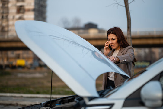 Woman calling for help with car breakdown on road