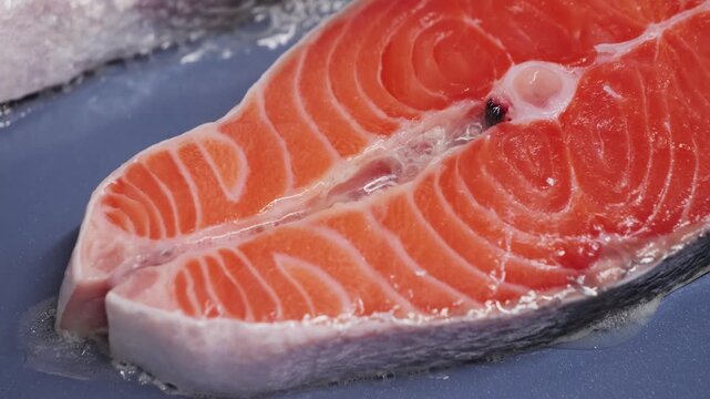 Salmon steak frying in a pan. Healthy seafood rich in omega-3 fatty acids, protein and nutritious fats. Cooking and healthy eating concept. High quality 4k footage