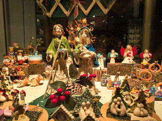 Obraz premium A cozy shop window display of handcrafted ceramic nativity figurines evokes warm holiday feelings of peace and joy during Christmas. Perfect festive background. Nobody is present.