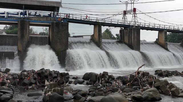 An aerial drone perspective reveals the historic Katulampa Dam spanning the Ciliwung River in Bogor