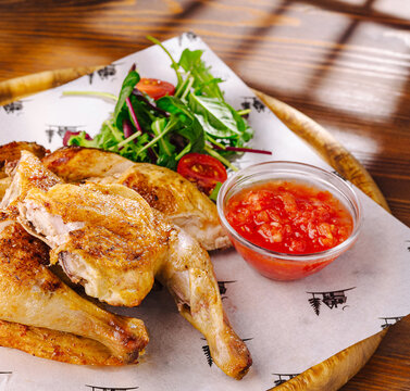 Roasted chicken with fresh salad and tomato salsa being served