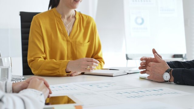 Business people team collaborating and analyzing financial data while taking notes during a corporate meeting in a modern office, highlighting teamwork and strategic planning