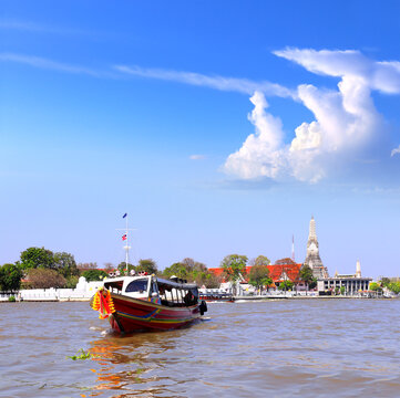 Traditional Thai long tail boat and buddhist Temple of Dawn Wat Arun, landmark of Bangkok, Thailand. Famous tourist attraction boat ride on Chao Phraya river. Summer vacation, topic of travel, trip
