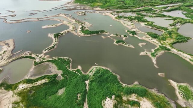 Aerial drone footage of a calm lake reflecting clouds and mountains at sunset light. Ideal for nature, travel, environment, wetland, and cinematic landscape projects.