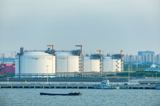 Large industrial storage tanks at waterfront energy terminal in Shanghai, China. Modern fuel storage and logistics infrastructure, energy distribution, maritime transportation, industrial operations