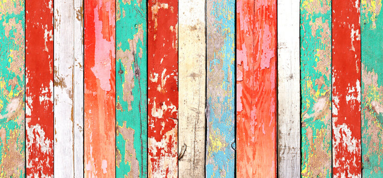 Texture of vintage wood board with cracked paint in various hues. Horizontal retro background with wooden plank with old paint of different color. Full pattern for banner or skinali with wood panels