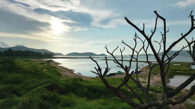 Aerial drone footage of a calm lake reflecting clouds and mountains at sunset light. Ideal for nature, travel, environment, wetland, and cinematic landscape projects.
