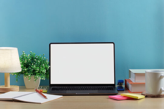 Laptop mockup with blank white screen on wooden desk for remote work