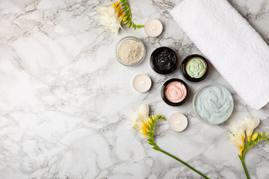 Cosmetic clay mask on a marble table. Paring a clay face mask. Skincare concept. Natural cosmetic made face mask. Healthy skin. Spa beauty concept. Body care. Flat lay. Copy space.