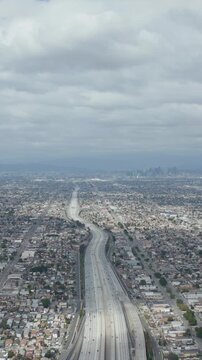 AERIAL: Spectacular View over Endless City Los Angeles, California with Big Highway Connecting to Downtown on Cloudy Overcast Day 