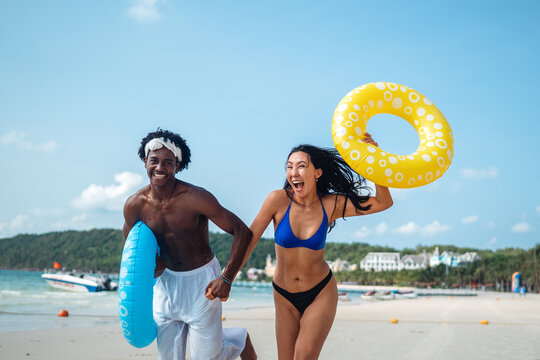 Happy couple having fun at the beach, playing and laughing together in a romantic tropical setting