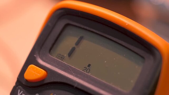 Close-up of a digital multimeter measuring an electronic component during repair and maintenance, highlighting electrical testing, troubleshooting and DIY electronics work