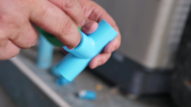 Close up of connecting a three-way PVC pipe fitting by hand for DIY home plumbing repair and water system maintenance.