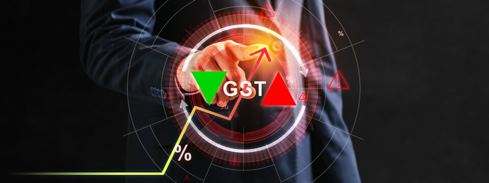 A businessman in a suit interacts with a futuristic digital interface showing GST text, percentage symbols, and upward and downward trend arrows representing tax rate changes