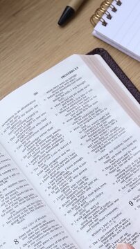 Reading and studying from open holy bible book. Vertical video. Christian biblical concept.