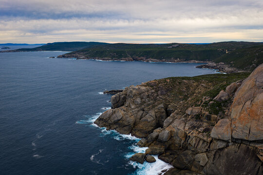 Aerial view of Jimmy Newells Harbour featuring rugged granite cliffs, deep blue ocean waters, and coastal vegetation in Albany, WA, Australia.