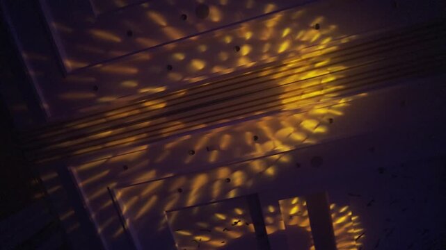 The lights shining from above the ballroom provide a dramatic and artistic touch.