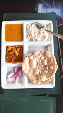 Overhead shot of a homemade authentic Indian thali meal with rice, bread & vegetable curries.