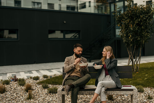 Business coworkers eating lunch, taking break outdoors