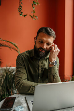 Bearded man remote working online in coffee shop