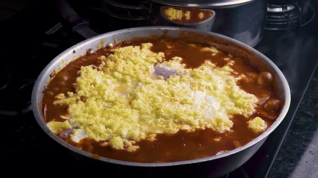 Close up of delicious sauce boiling with melting cheese in a pan
