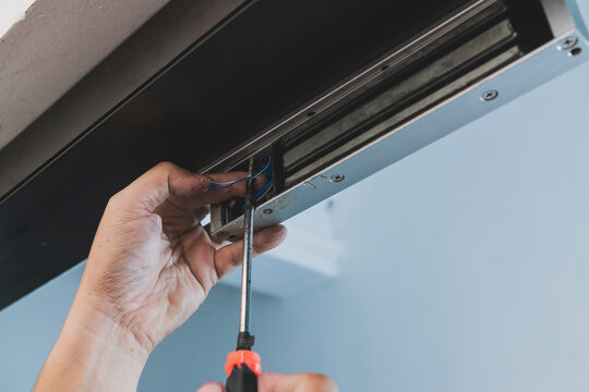 Close up of a technician connecting wires during electromagnetic door lock installation, supporting access control, security, and entry management.