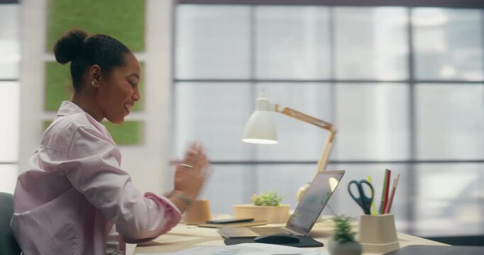 360 Degree. Young Black Woman Entrepreneur Works on Laptop in Office, Analyzing Business Data Charts, Managing Ecommerce and Finance With Digital Technology. Orbital Cinematic Arc Tracking Shot.