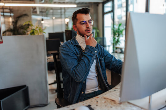 Young businessman thinking and concentrating on computer