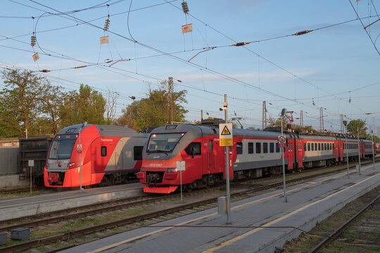 TAGANROG, RUSSIA - MAY 07, 2025: Two suburban electric trains 1ES Lastochka and EP3D at Taganrog station in the early morning of May