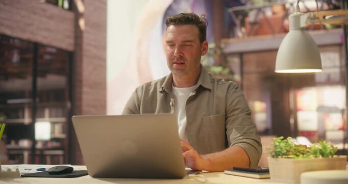 360 Degree. Man Types on Laptop in Trendy Loft Office, Developing Ecommerce Platform, Processing Payment Transactions and Optimizing Digital Sales Strategy for Startup Growth. Arc Tracking Shot.