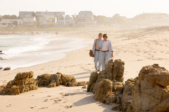 Young woman and boy exploring coastline of Onrus Beach, Onrus, South Africa