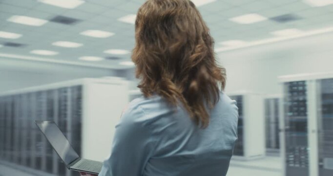 360 Degree. Male and Female It Professionals Operate Laptop Together While Inspecting Server Hardware in a Data Center, AI Network Systems and Cloud Performance. Orbital Cinematic Arc Tracking Shot.
