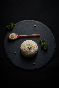 Oat groats and steamed oat rice laid out on a black bluestone slab