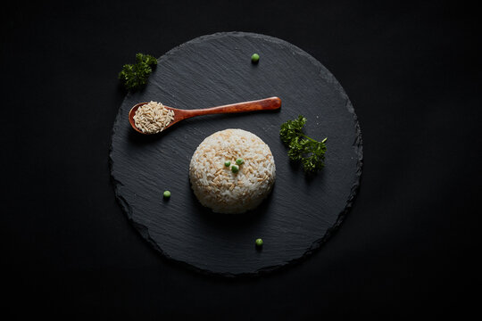 Oat groats and steamed oat rice laid out on a black bluestone slab