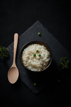 Oat groats and steamed oat rice laid out on a black bluestone slab