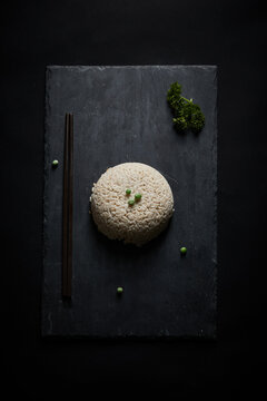 Oat groats and steamed oat rice laid out on a black bluestone slab
