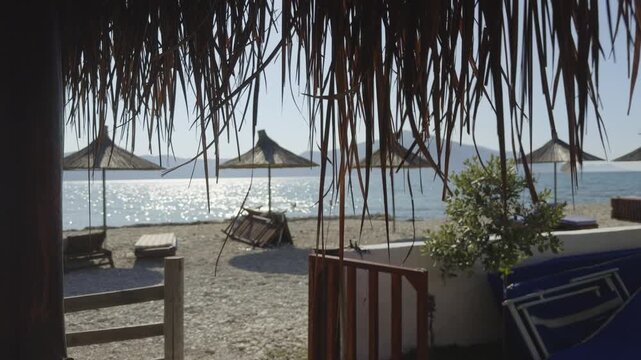 Pebble Sandy Beach With Sun Umbrellas Sunbeds Coast On Sunny Summer Day. Marine Resort