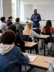 Obraz premium A teacher engages a diverse group of students in a modern classroom setting. Interactive learning environment.