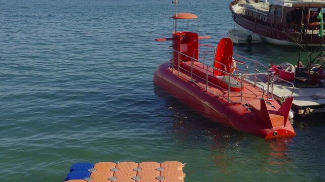 Red Semi Submarine. TouristBoat Anchored Near Floating Pier. Excursion Vessel For Underwater Sea Life Exploration