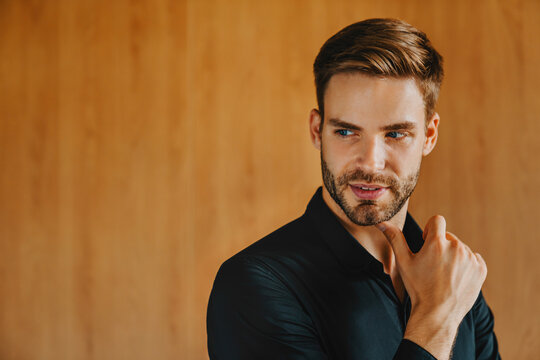 Serious handsome businessman touching chin while thinking deeply about question, confident male professional showing thoughtful expression, corporate planning and analytical mindset concept