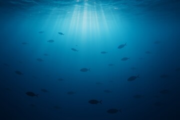 Fototapeta premium Silhouettes of fish swimming in deep ocean with sunlight rays piercing through water surface, peaceful underwater background concept. Ai generative. Ai generative