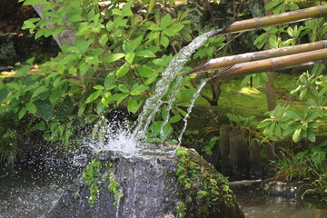 Water flowing from the bamboo spout into the rock © Mt. Cape