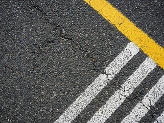 Fototapeta premium Close-up View of Asphalt Road Surface with Yellow and White Traffic Lines