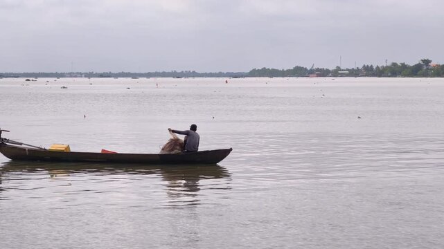 A local fisherman casting a net on the river near Binh Thanh floating village, Sa Dec, Vietnam