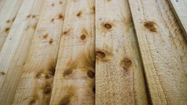 Garden fence texture revealing vertical wooden planks with detailed grain patterns. Exterior boundary installation representing landscaping maintenance and property enhancement work. Timber