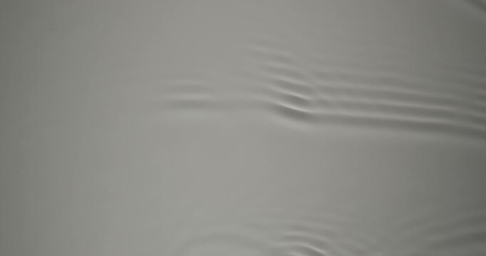 Calm water ripples on surface. Soft ripples move gently across the calm water, creating a sense of tranquility. The light reflections form a delicate, meditative pattern. 
Video in loop.