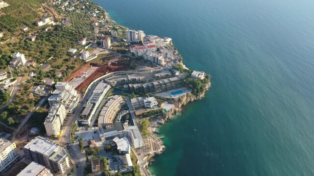 Bird's-eye aerial view of the beaches, coastline, and coastal settlements along the Albanian Riviera in Vlor&euml;, Albania, filmed by drone in stunning detail.