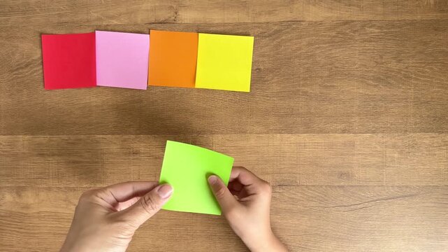 Child Hands Receive a Colorful Origami Square and Line It Up in a Row, 4K