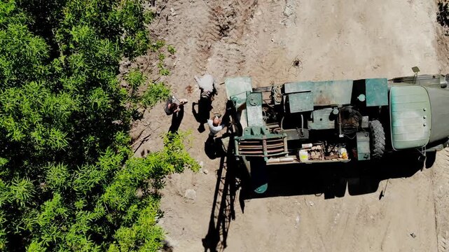 Aerial drone view of a mobile geotechnical drilling rig conducting soil investigation and ground sampling at a future construction site near a forested area in Sumy, Ukraine. The specialized drilling 